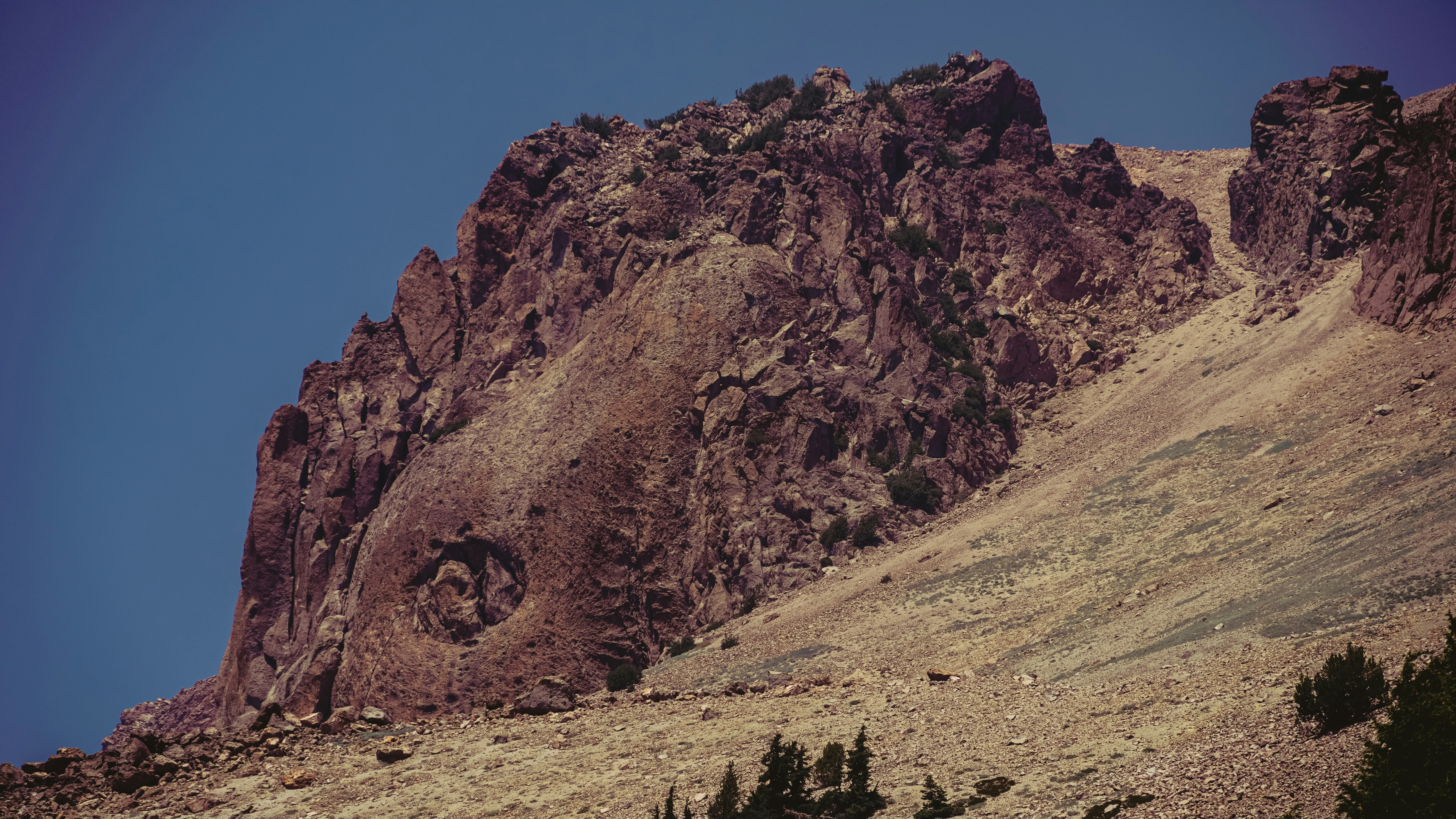 a mountain with a face carved into the side of it, 
