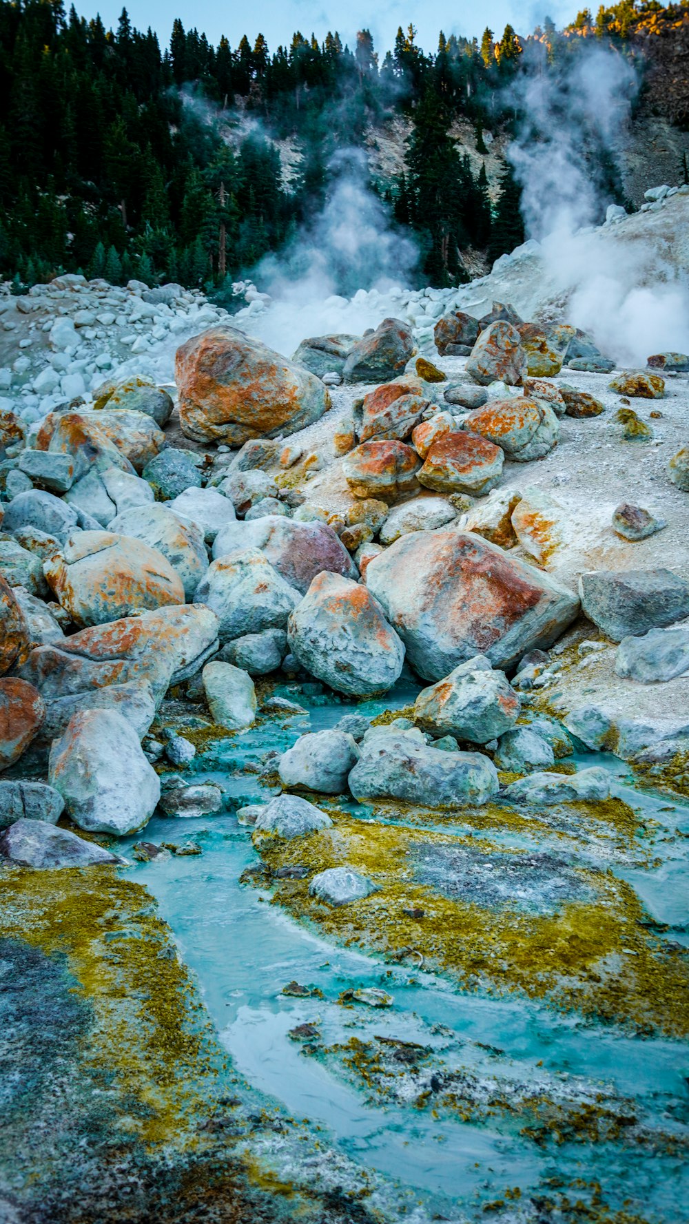 a stream of water surrounded by rocks and trees