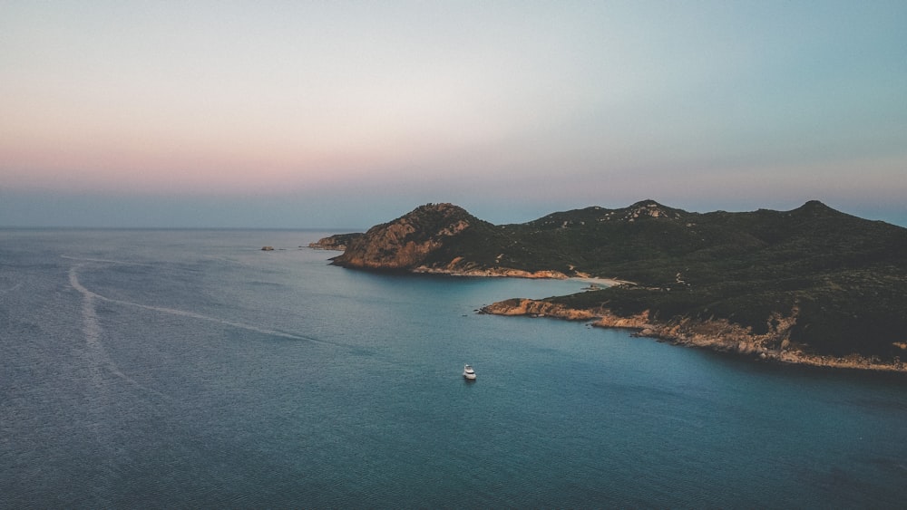 a boat is out on the water near some mountains