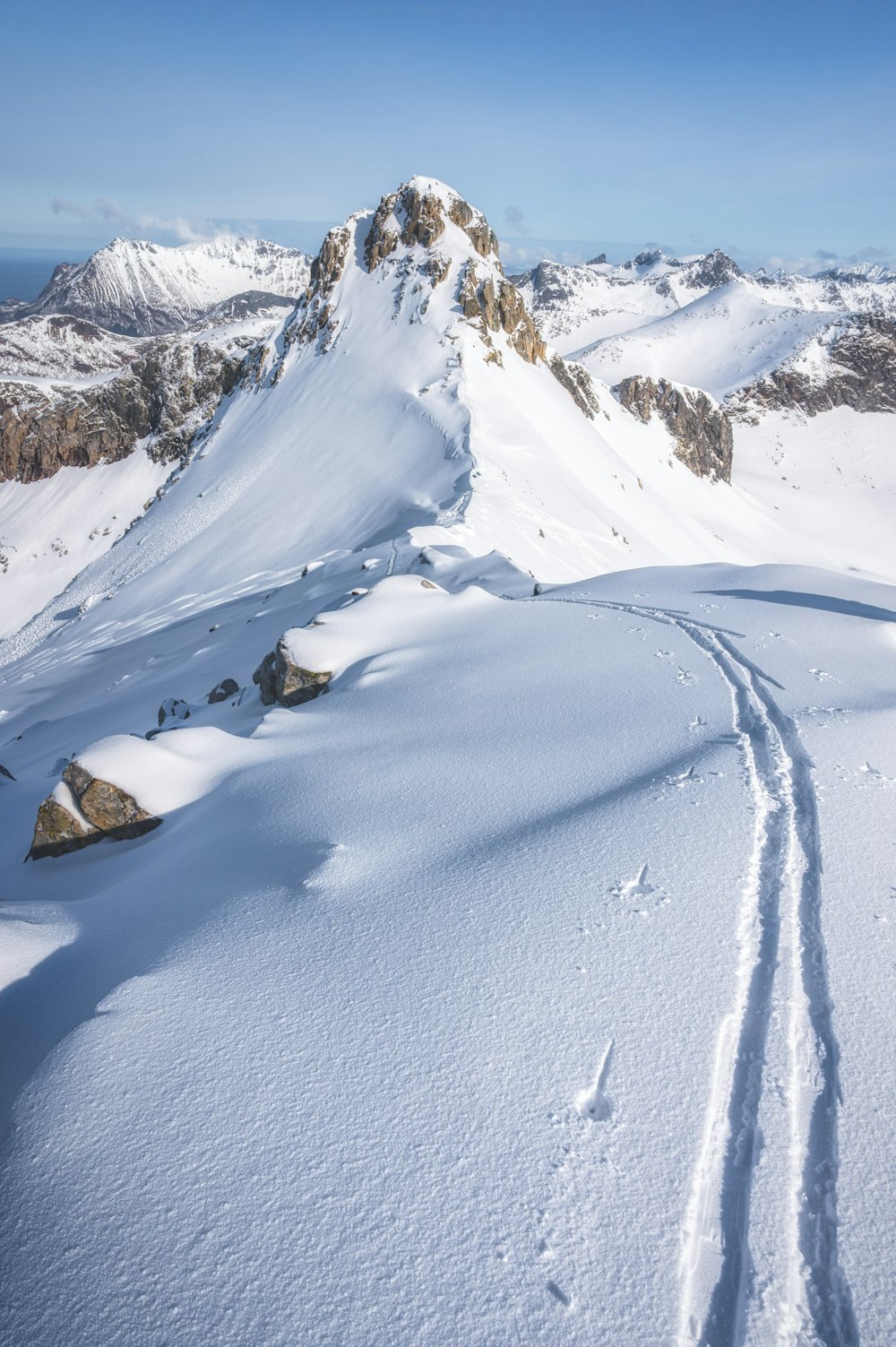 a snow covered mountain with tracks in the snow