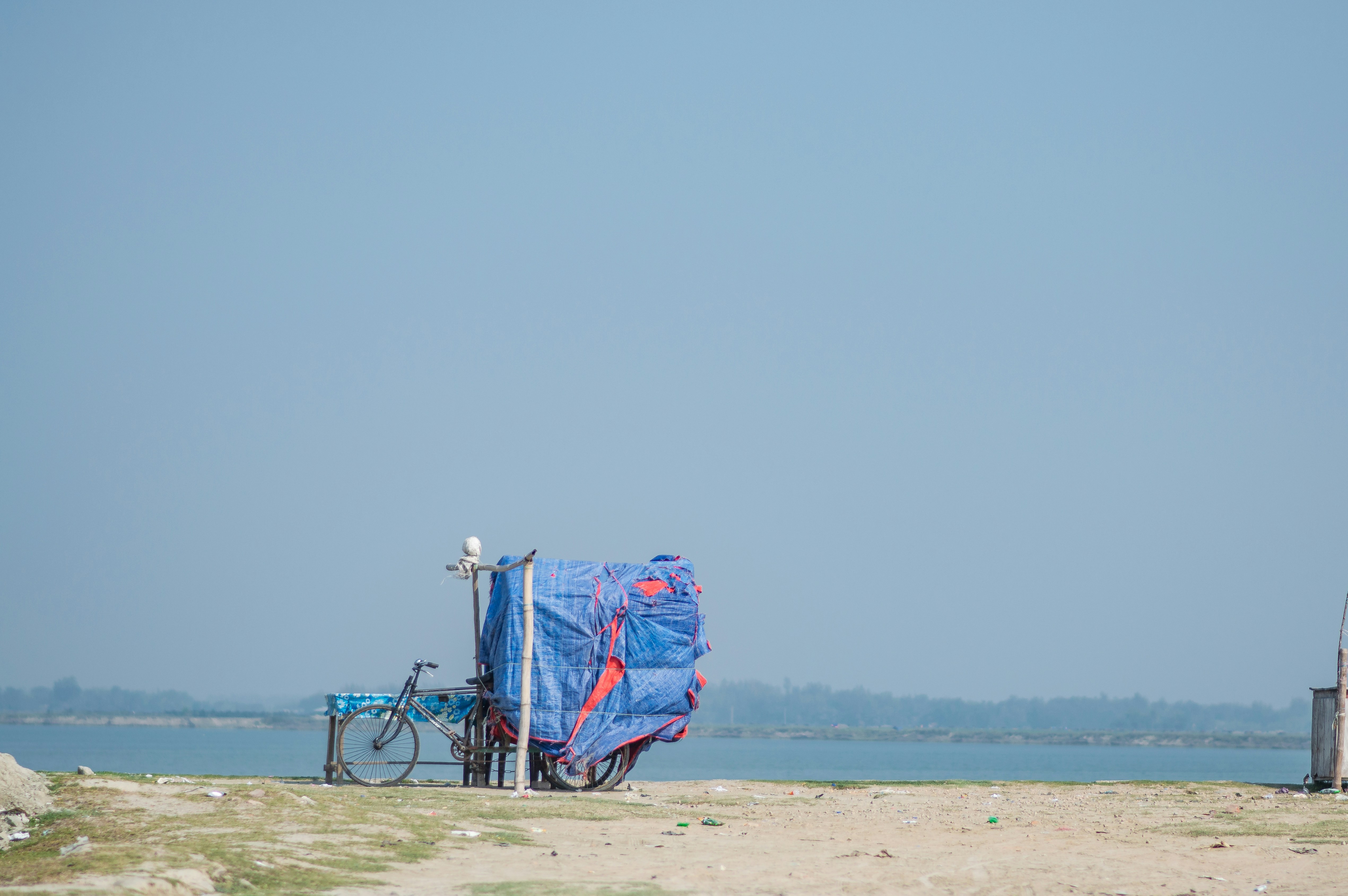 Une bâche bleue recouvrant un vélo sur une plage photo Photo Bleu