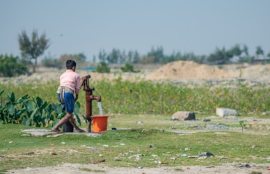 a man standing next to a water pump