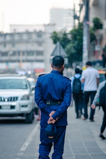 a man in a blue suit is standing on the sidewalk