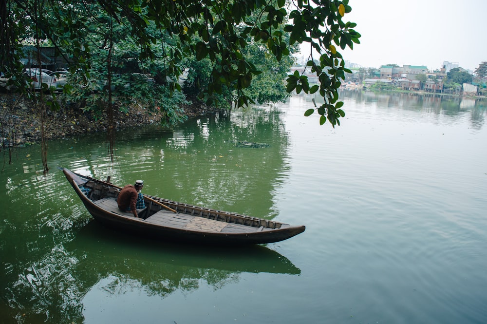 a man sitting in a boat on a body of water