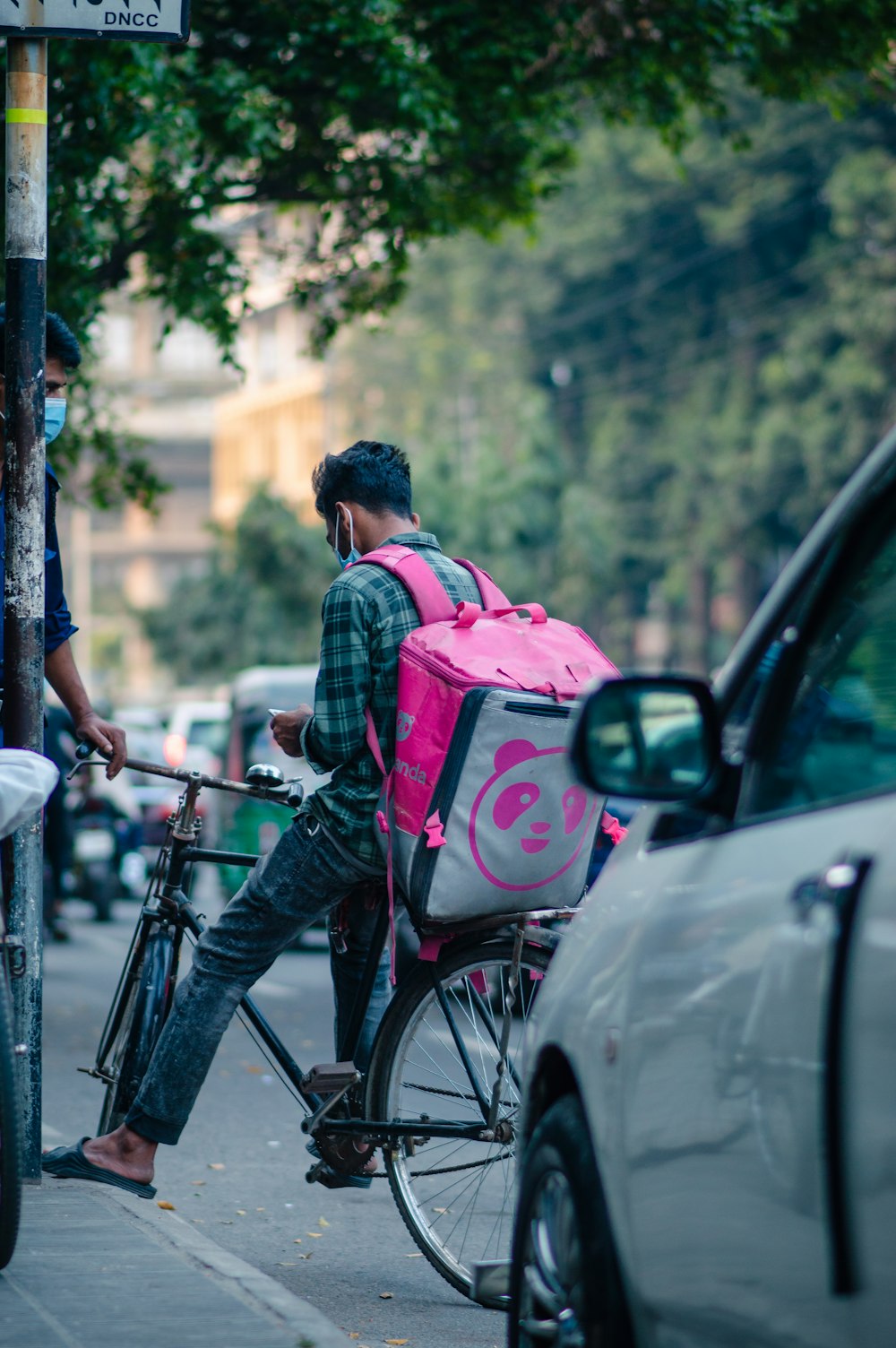 a man riding a bike with a pink backpack on the back
