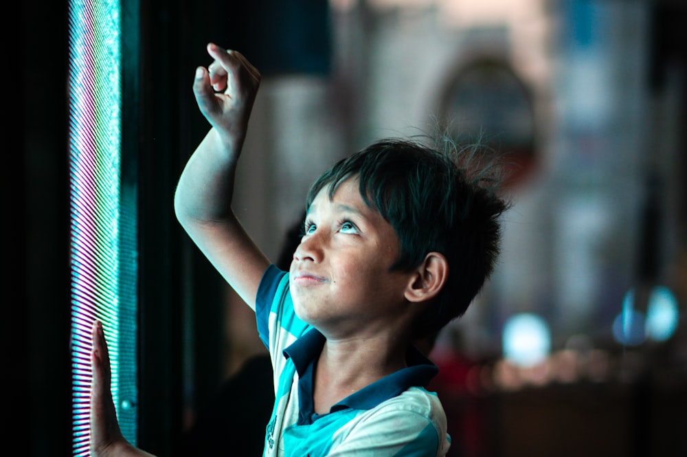 a young boy is looking up at the sky