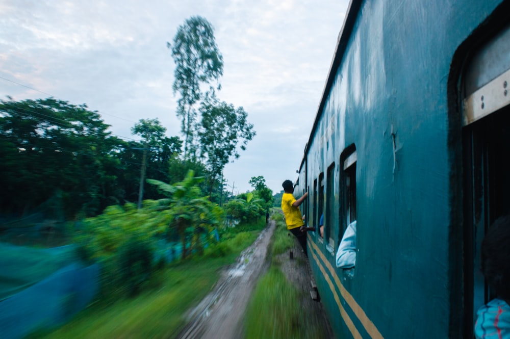 a man in a yellow shirt is looking out the window of a train