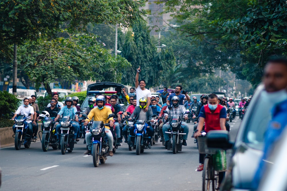 a group of people riding motorcycles down a street