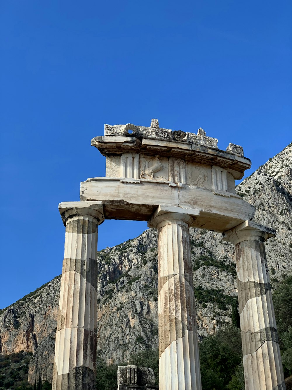 a stone structure in front of a mountain