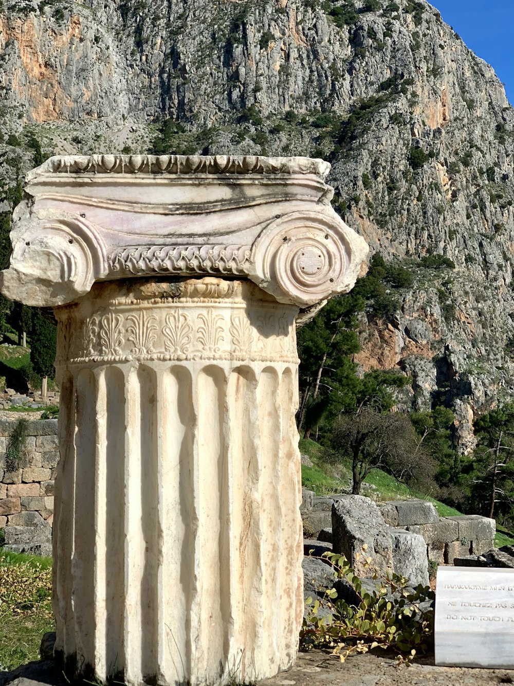 Un gran pilar de piedra sentado frente a una montaña