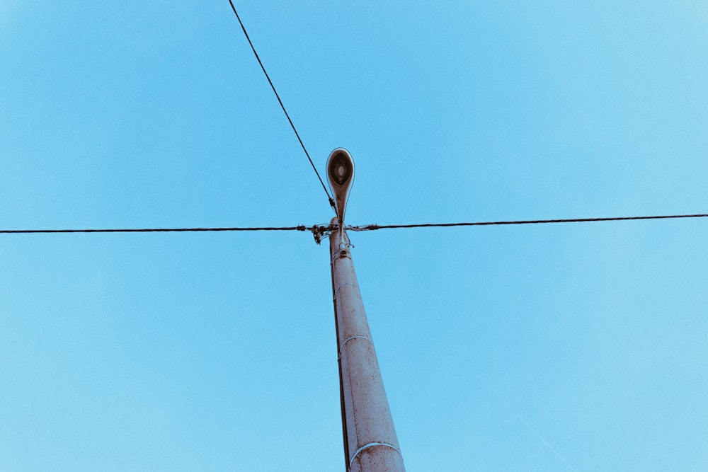 un lampadaire sur un fil avec un ciel bleu en arrière-plan