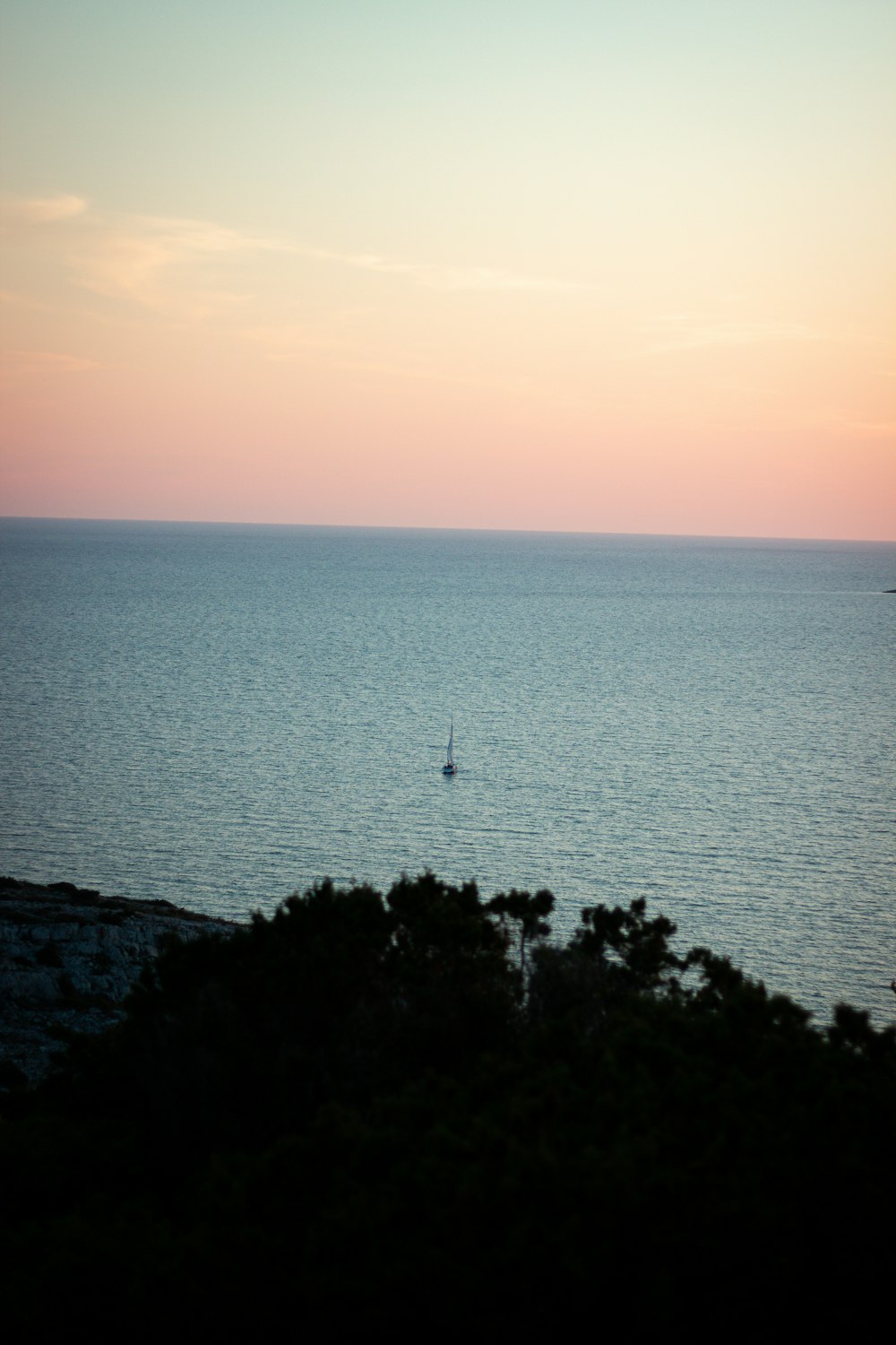 a boat is out in the ocean at sunset