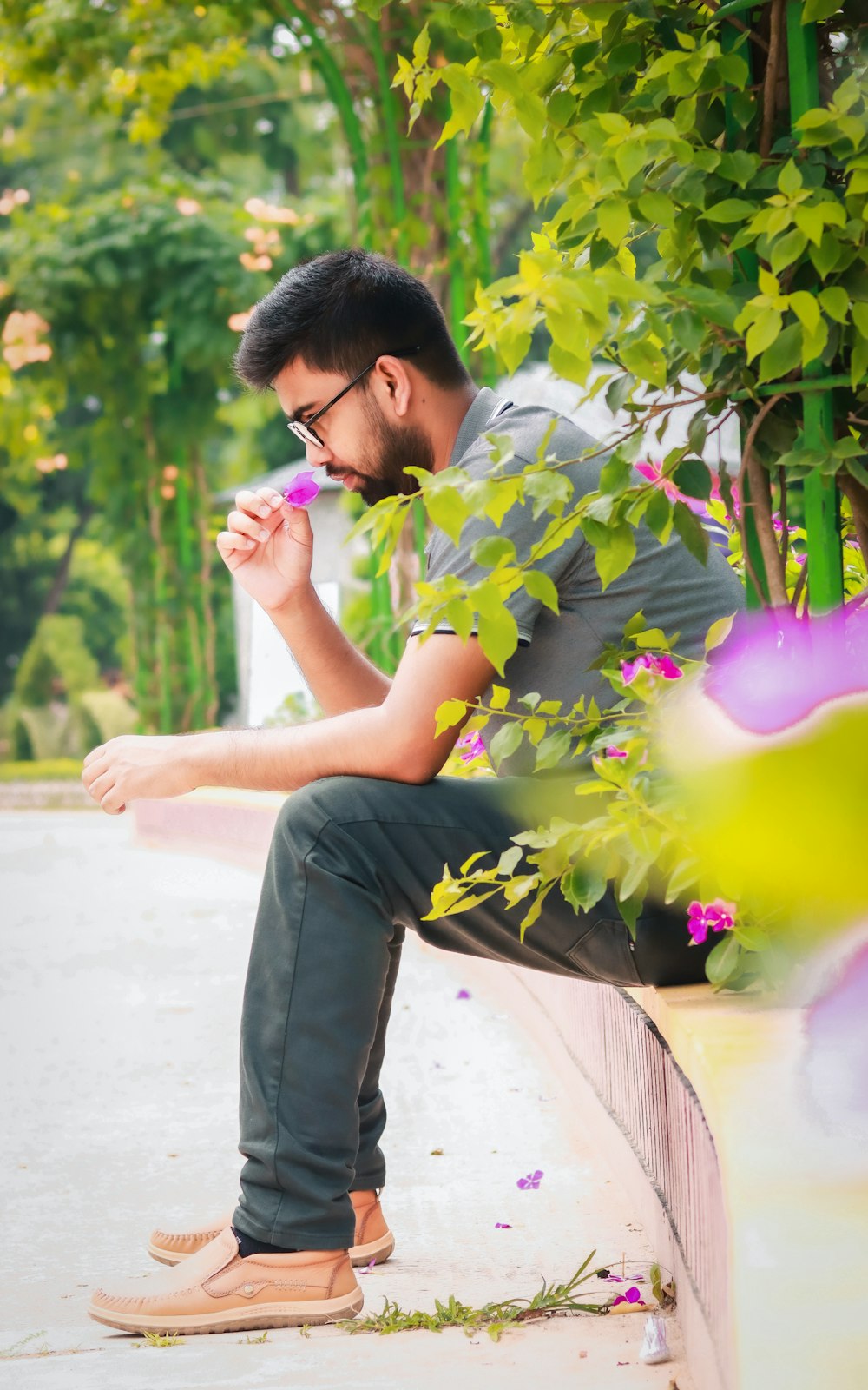 a man sitting on a wall with a flower in his hand