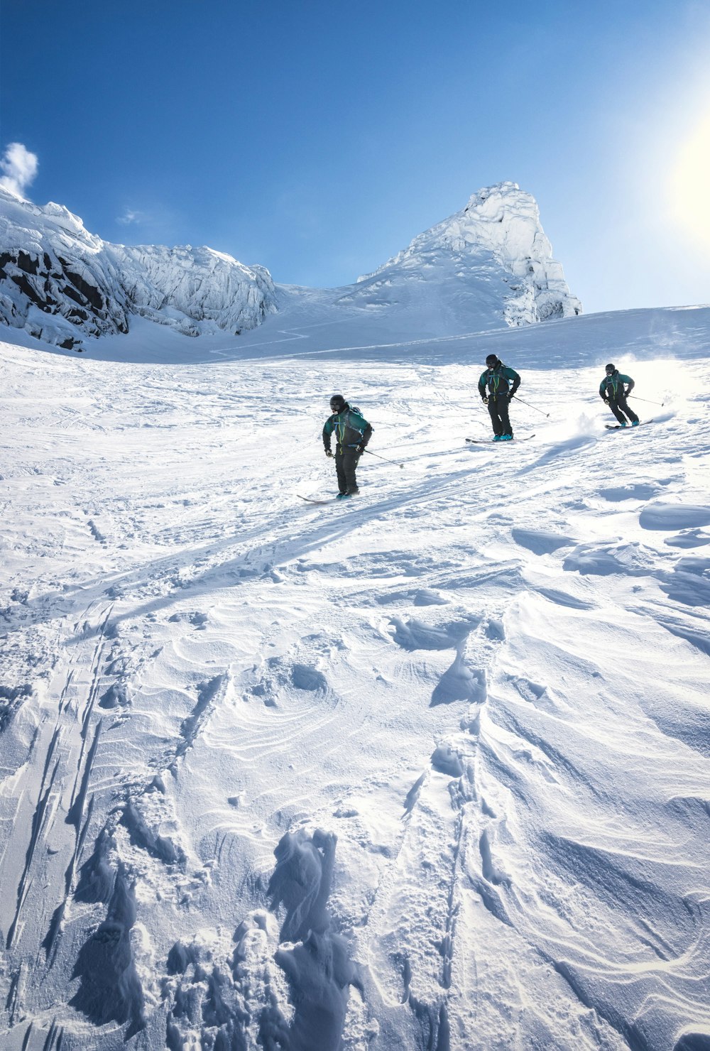 a group of people riding skis down a snow covered slope