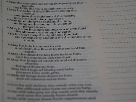 The image depicts a close-up of a page with printed text. The text appears in two columns, with a section of bullet points or numbered lines on the left. The page contains a passage likely from a religious or literary book, with a faint heading at the top.