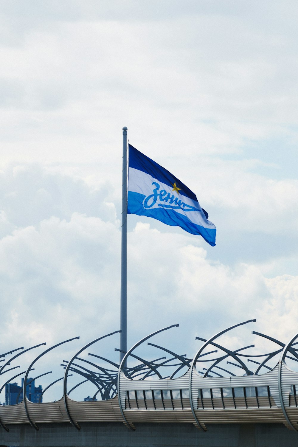 a blue and white flag flying on top of a bridge