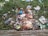 A collection of assorted litter scattered on grass, including plastic bags, wrappers, cardboard, and bottles.