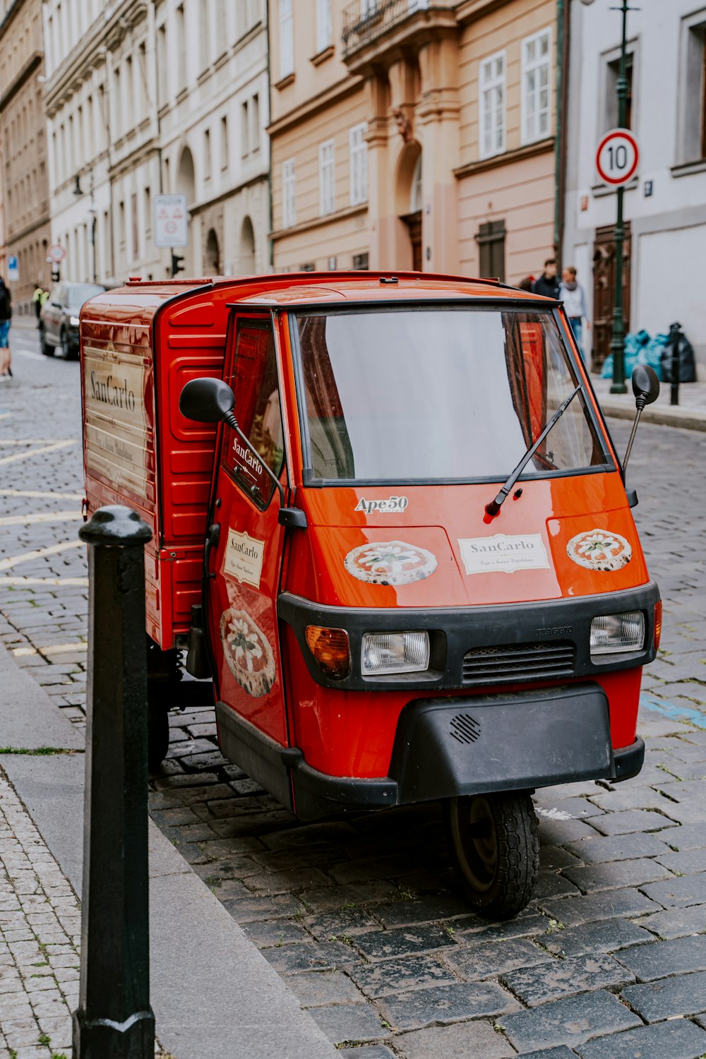 a small red truck parked on the side of a street