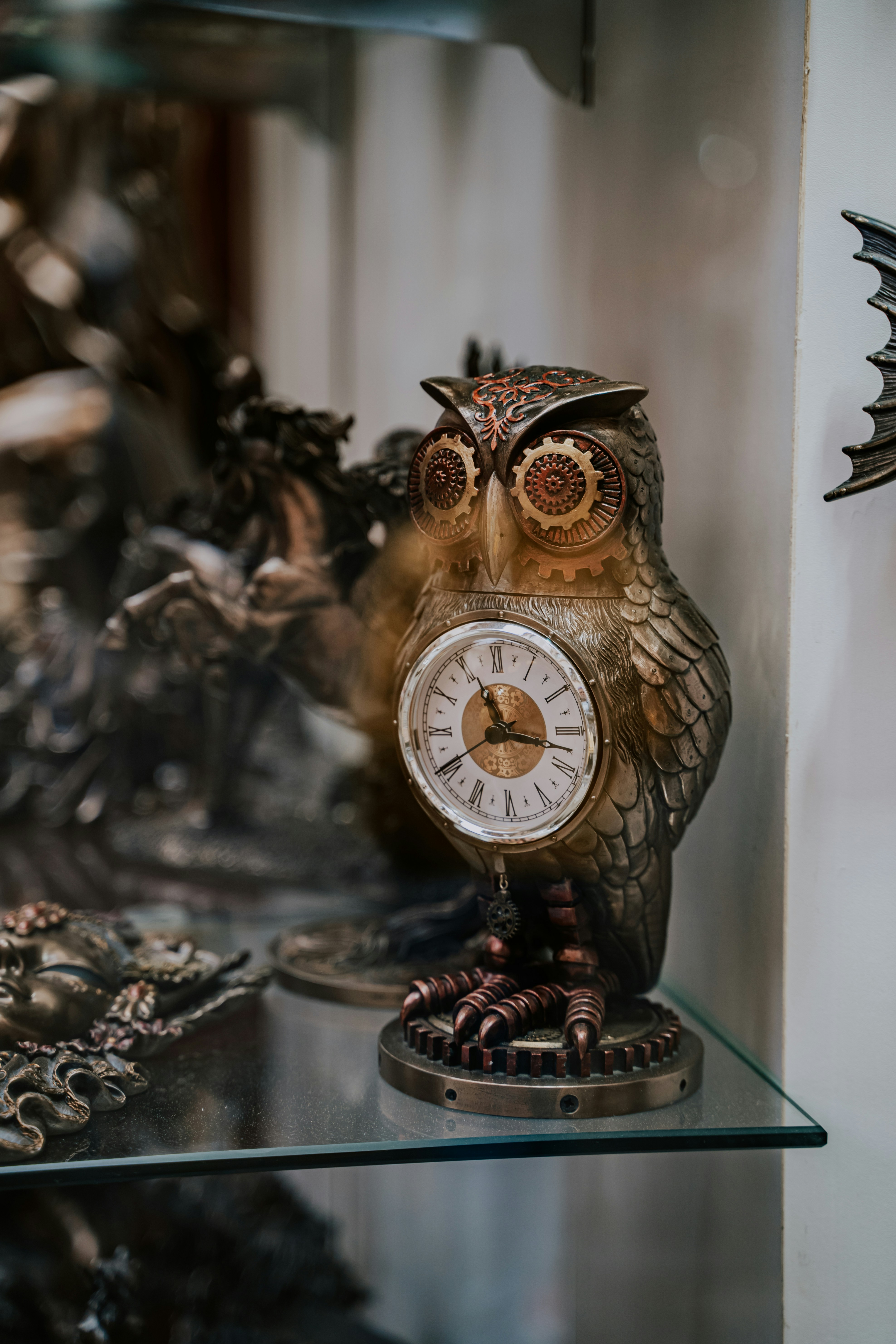 an owl figurine sitting on top of a glass shelf