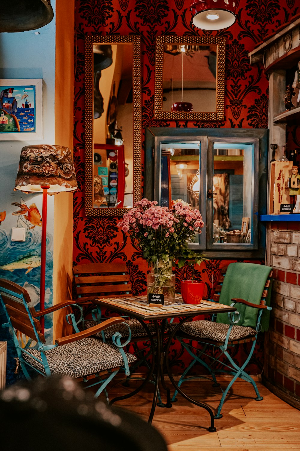 a table and chairs in a room with red wallpaper