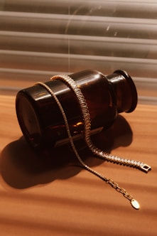 a bottle with a chain attached to it sitting on a table