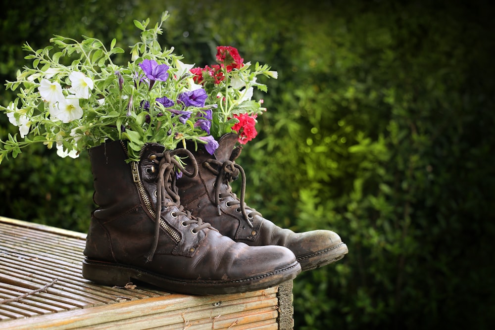 a pair of boots with flowers in them