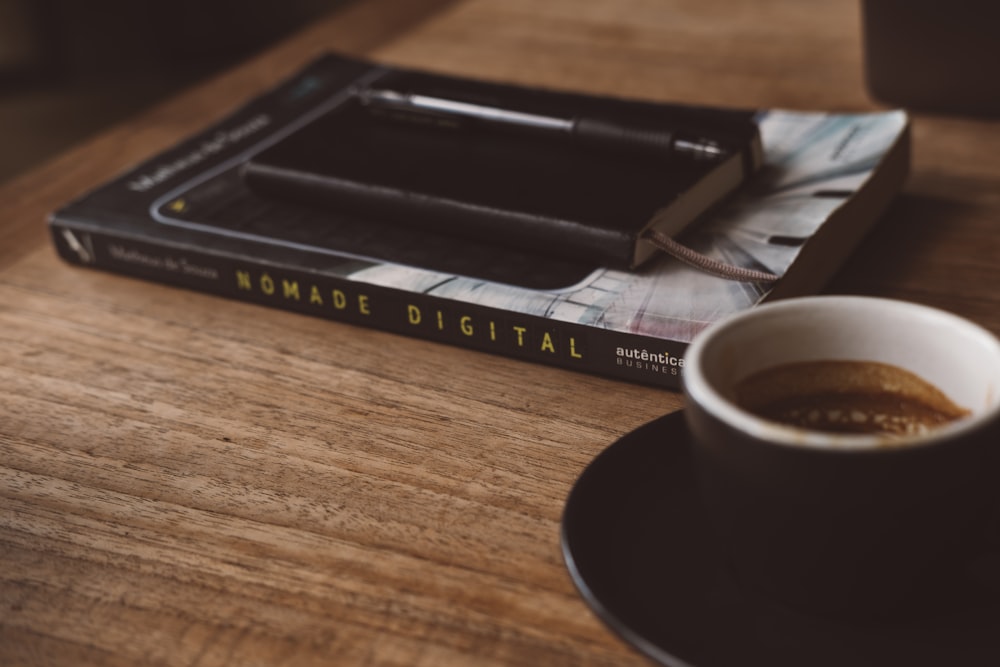 a cup of coffee sitting on top of a wooden table