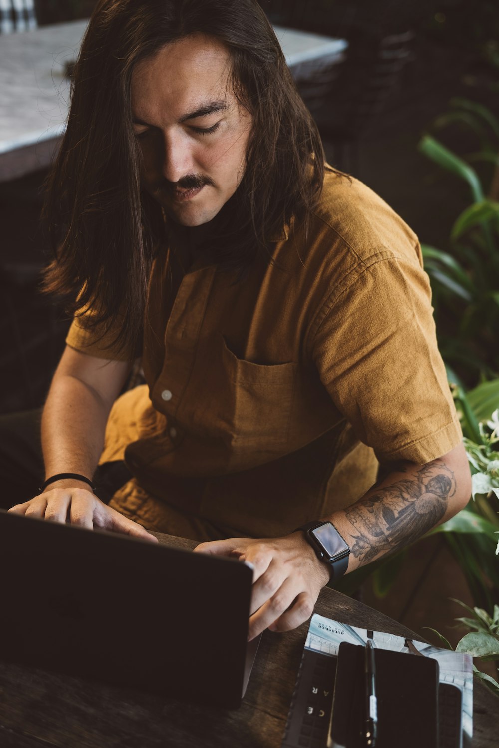 a man sitting at a table using a laptop computer