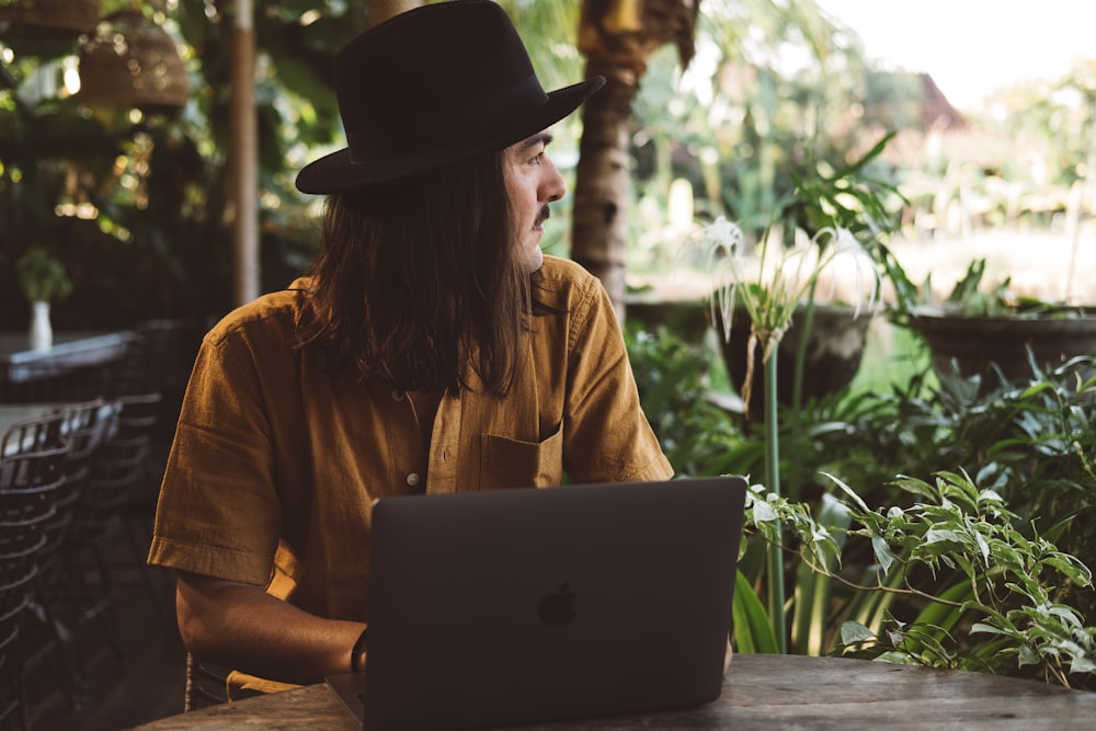 a man sitting at a table with a laptop