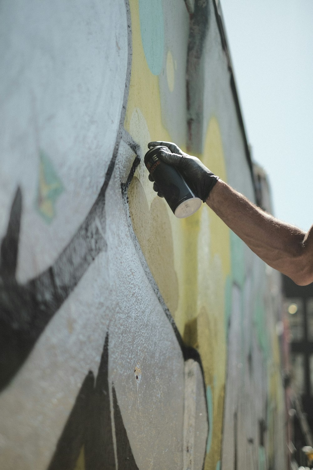 a man painting a wall with spray paint