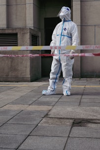 a man in a white suit standing in front of a building