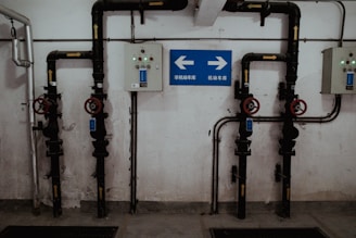 a room with pipes and a sign on the wall