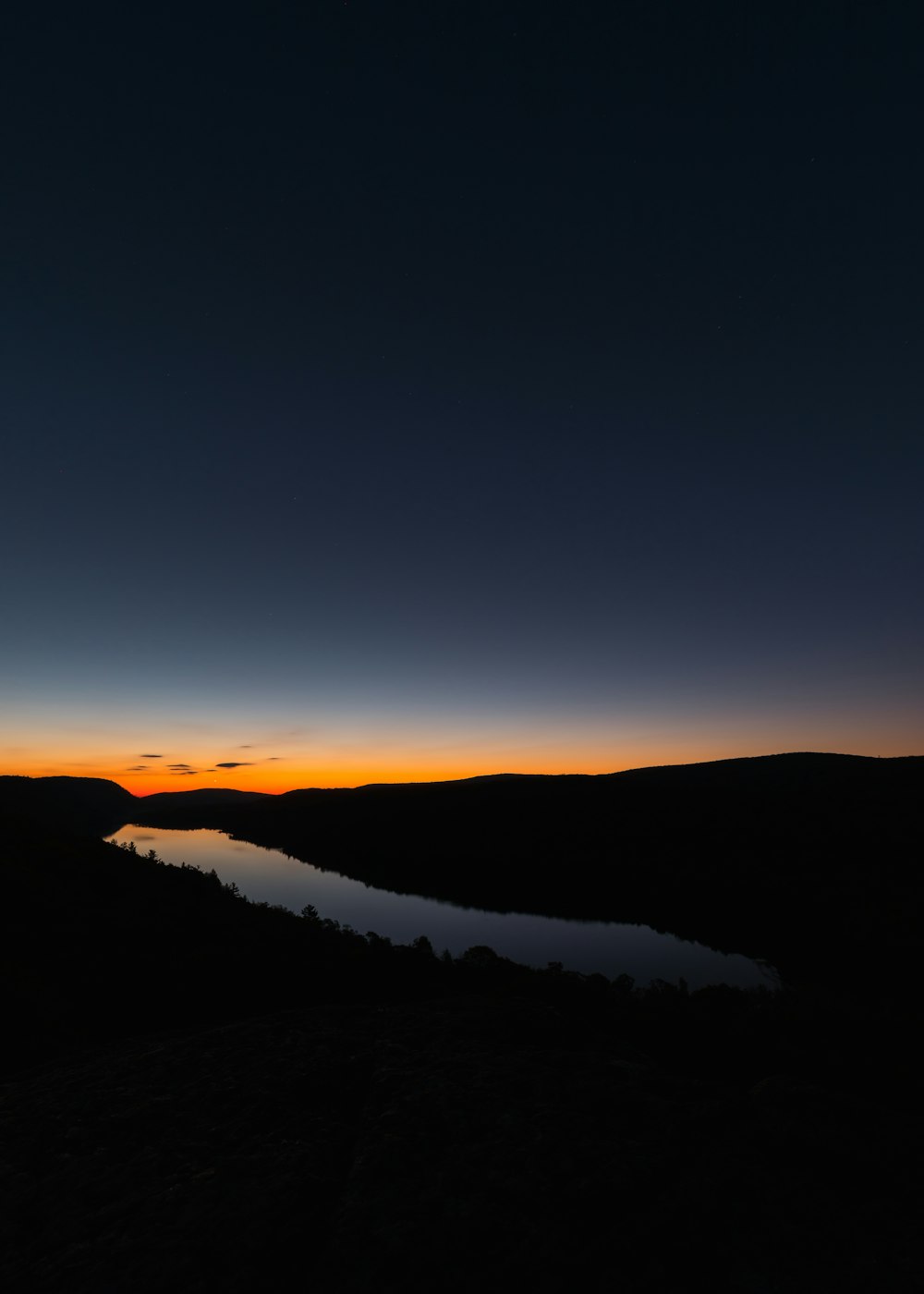 Die Sonne geht über einem Gewässer unter