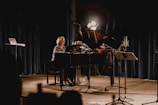 An atmospheric concert scene with a spotlight on the pianist.