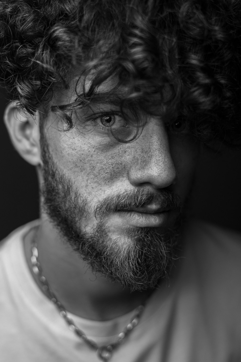 a black and white photo of a man with curly hair