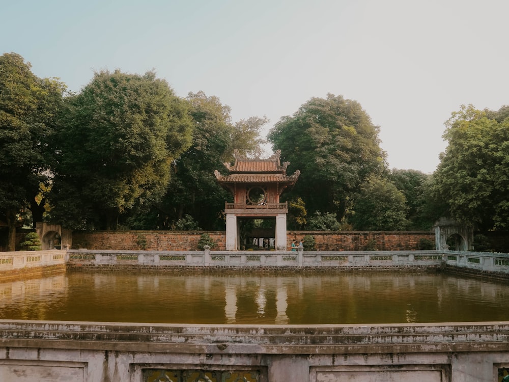 a pond with a pavilion in the middle of it