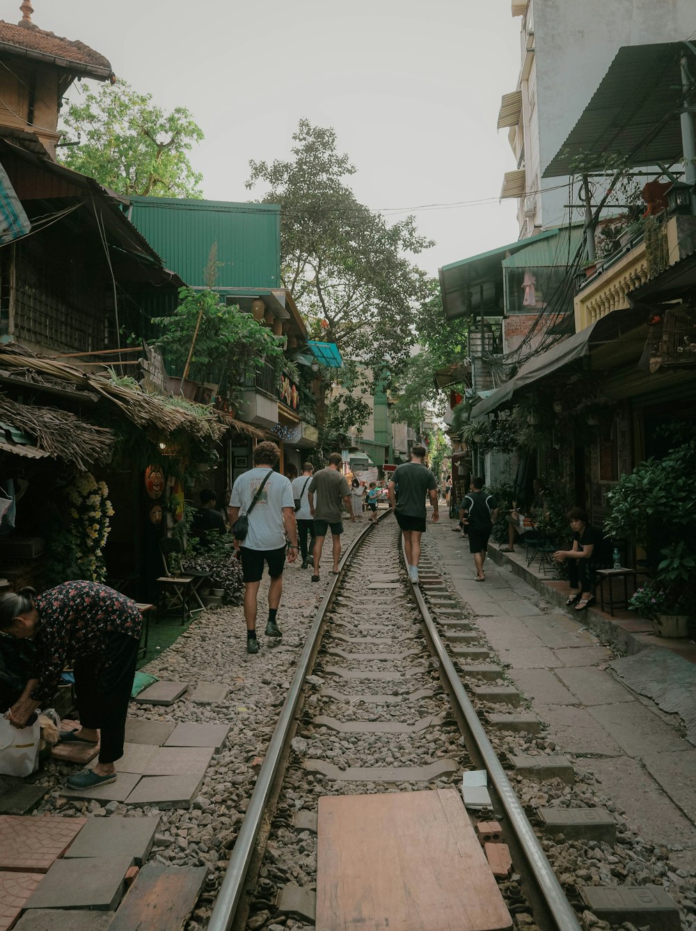 a group of people walking down a train track