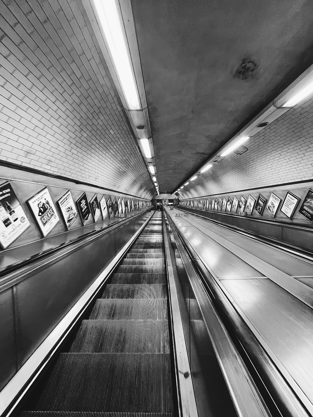 a black and white photo of an escalator