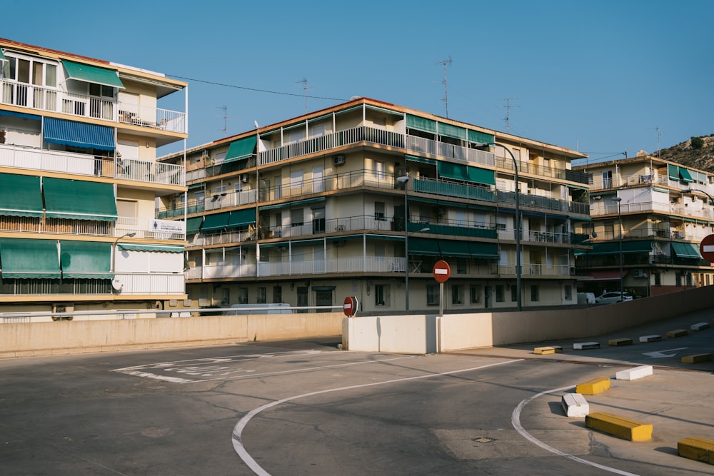 an empty parking lot in front of a building with balconies