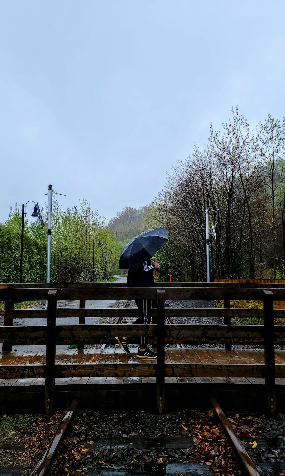 a person standing on a bridge holding an umbrella