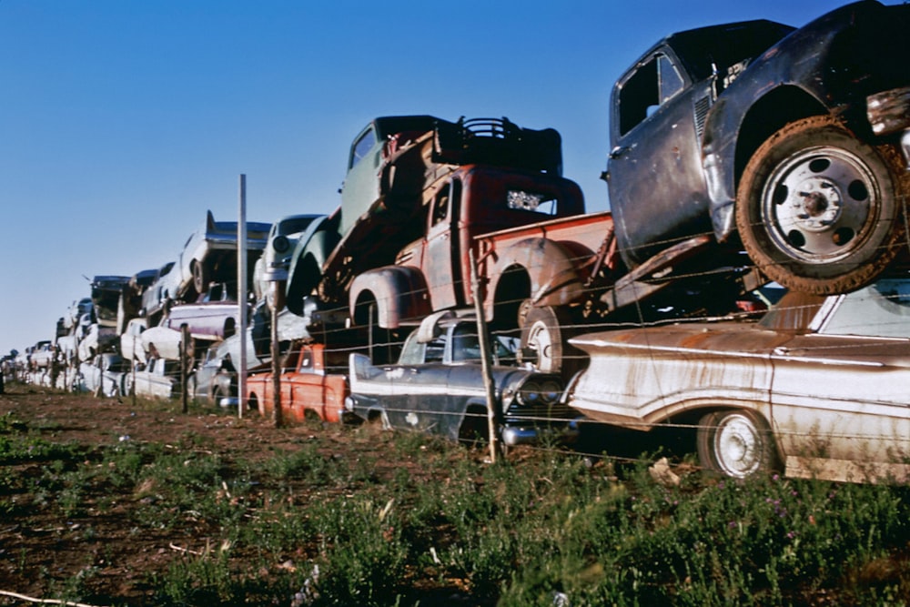 a row of old trucks sitting on top of a grass covered field