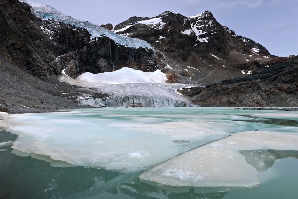 a mountain range with ice and snow in the foreground