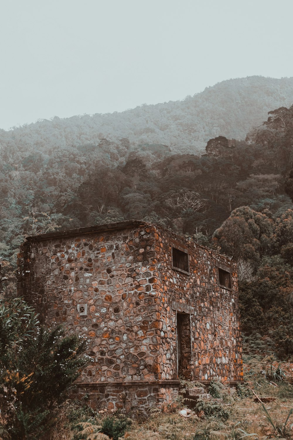 a stone building sitting in the middle of a forest