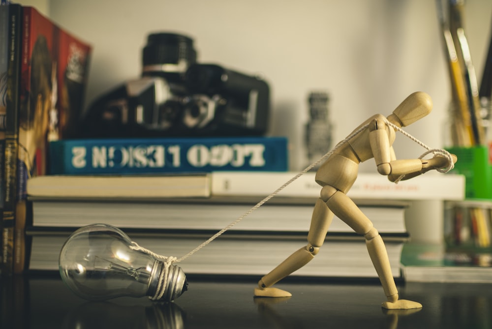 a wooden toy pulling a light bulb on a table