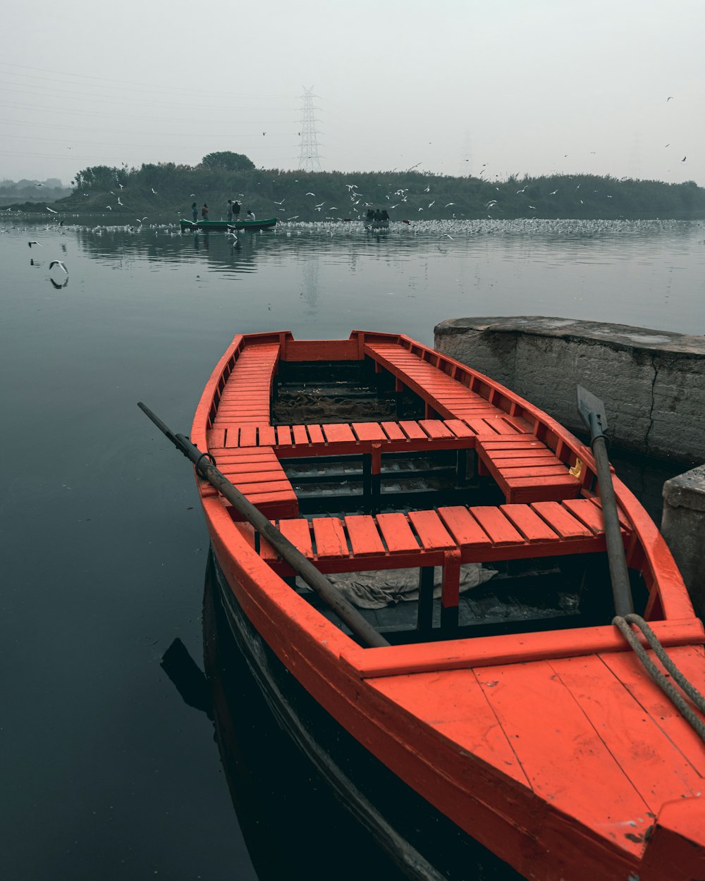 a red boat sitting on top of a body of water