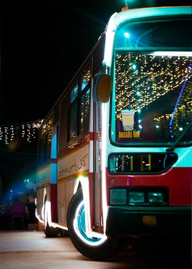 A sleek party bus with vibrant interior lighting ready to host a joyful group celebration at night.