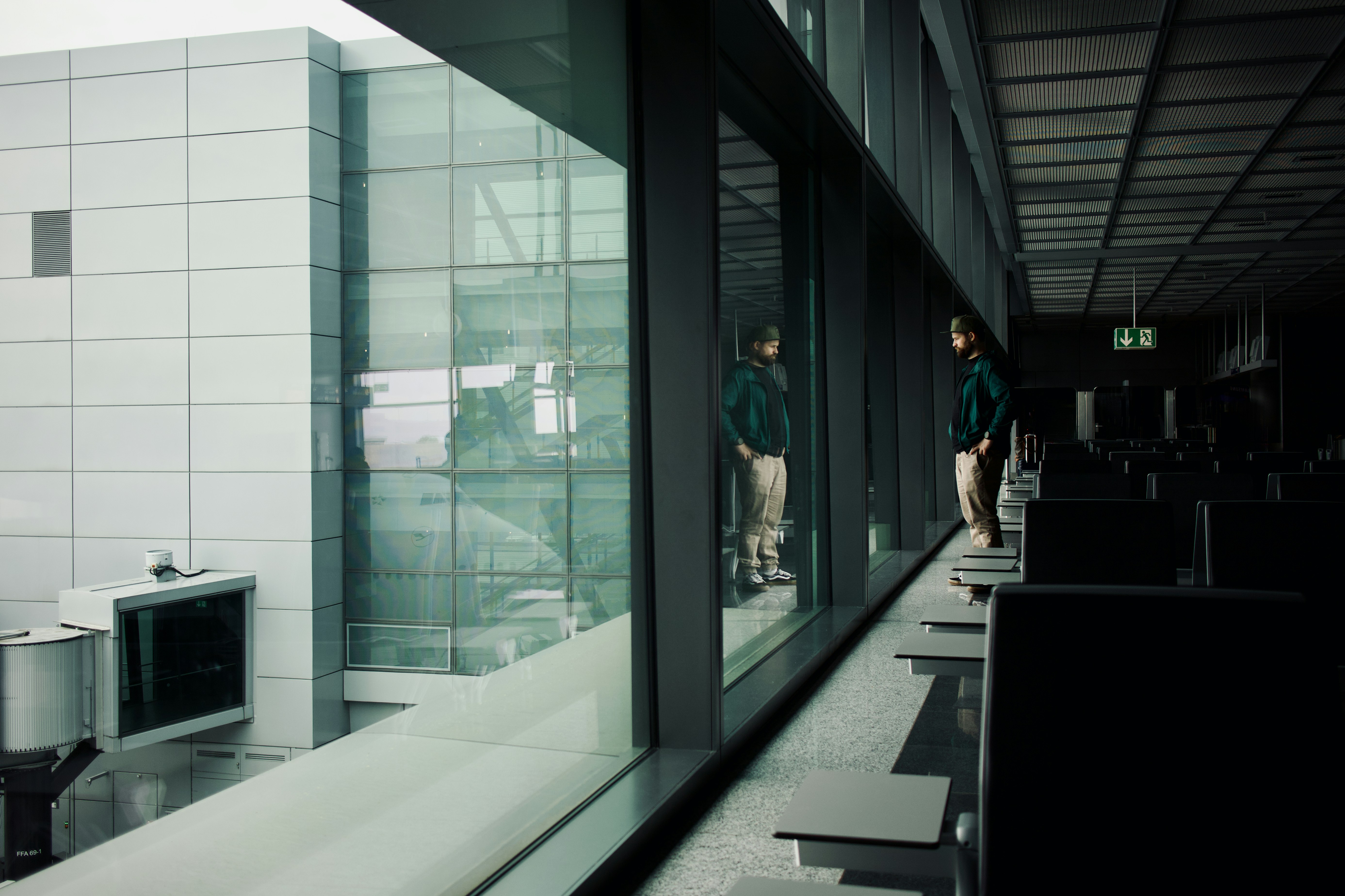a couple of people standing next to each other near a window, 