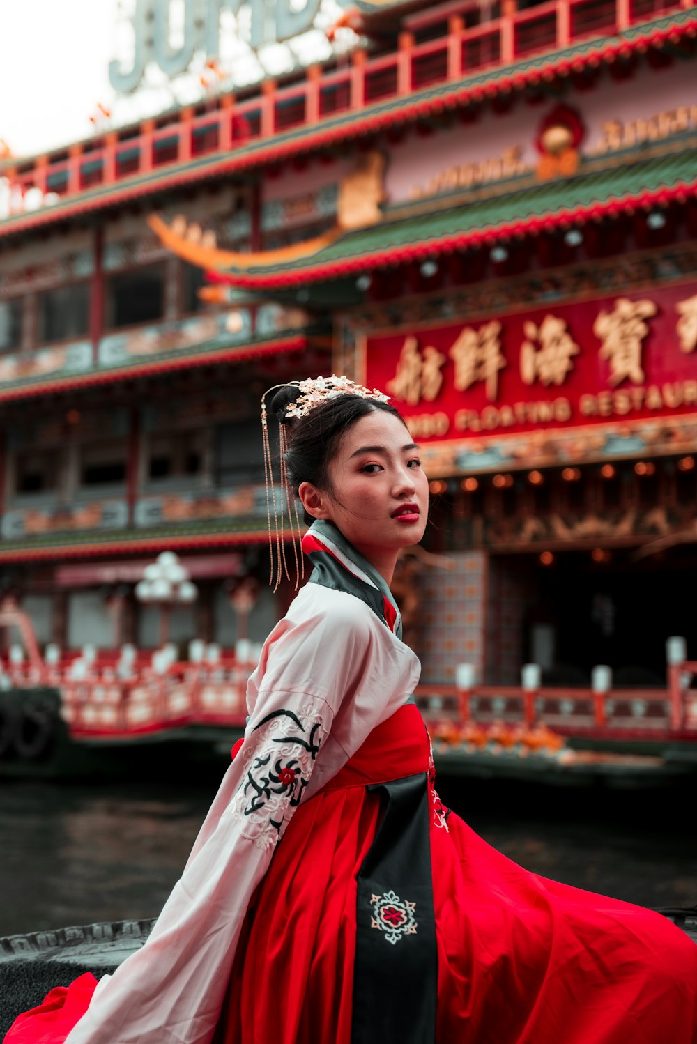 a woman in a red and black dress standing in front of a building