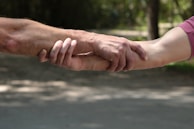 a close up of two people holding hands