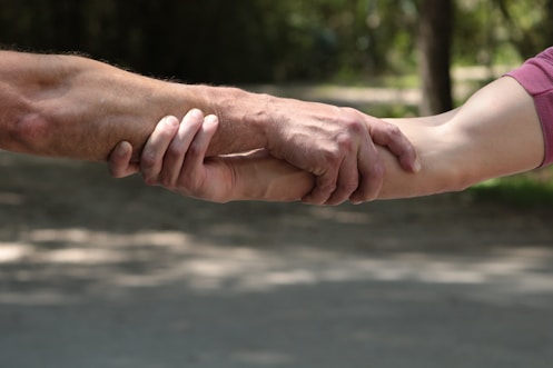 a close up of two people holding hands